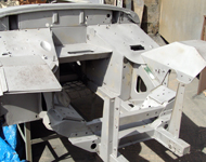 Car body being cleaned by sandblasting.